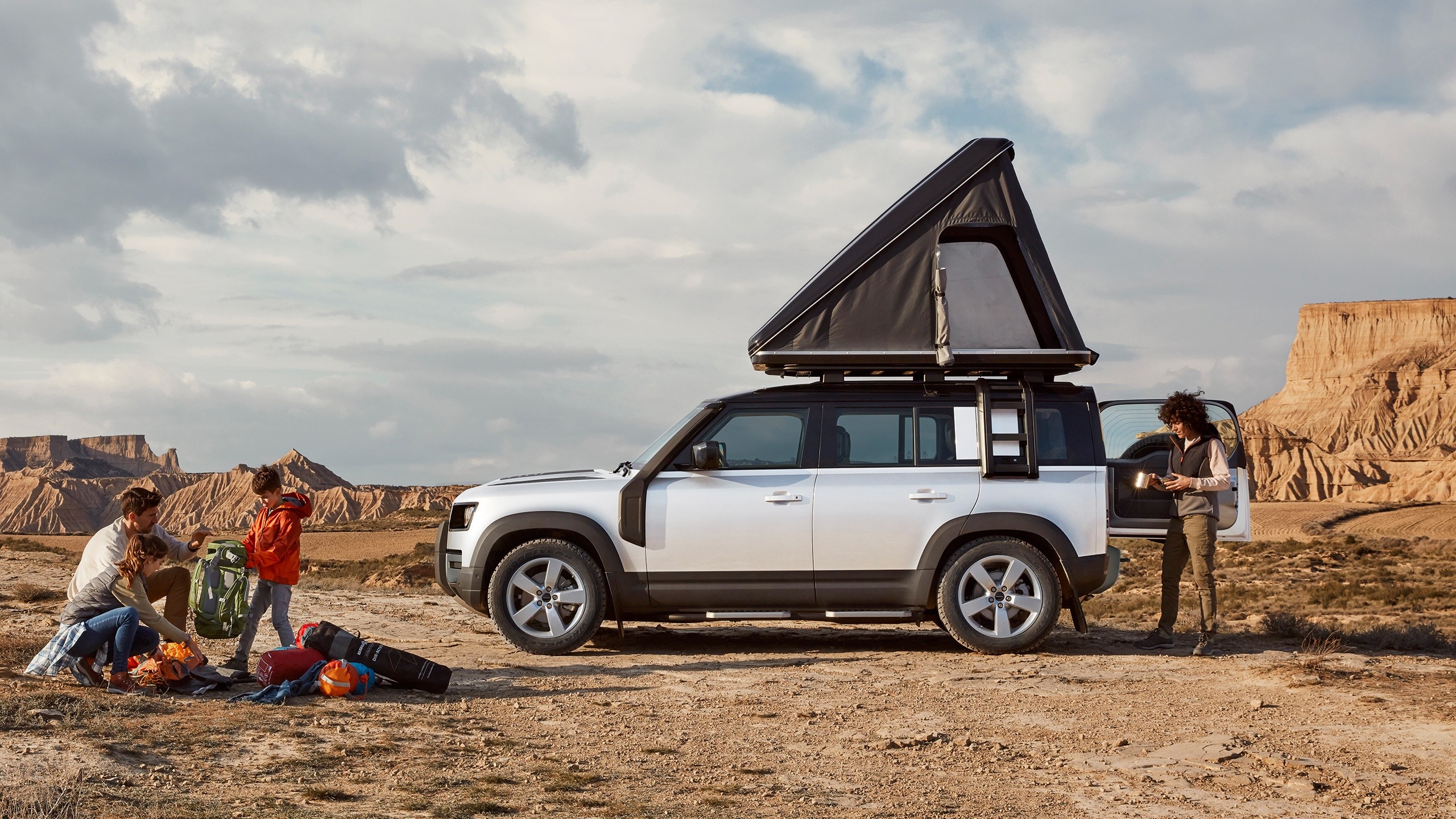 Land Rover Defender with rooftop tent showcasing outdoor adventure and off-road