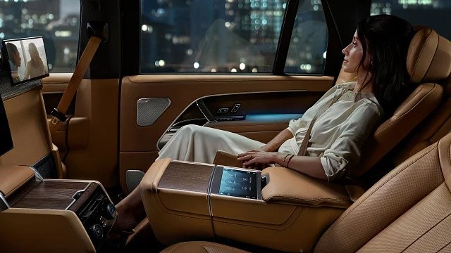 Land Rover Range Rover premium rear cabin with luxury leather seats, touchscreen controls, ambient lighting,