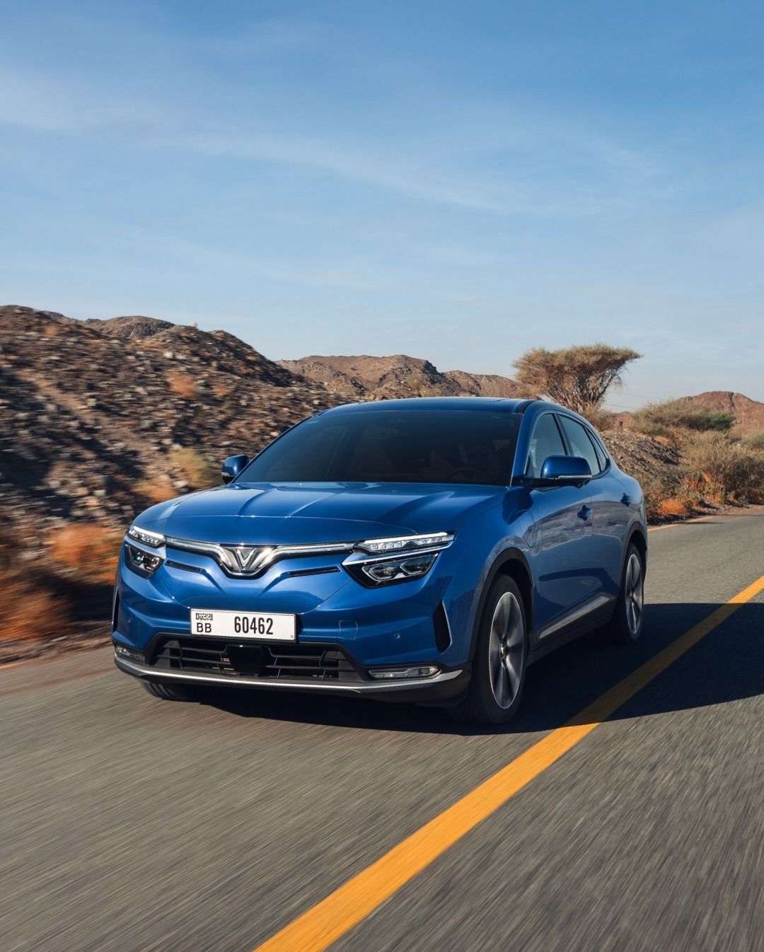 Vinfast VF8 on mountain road, three quarter view, blue colour vf8