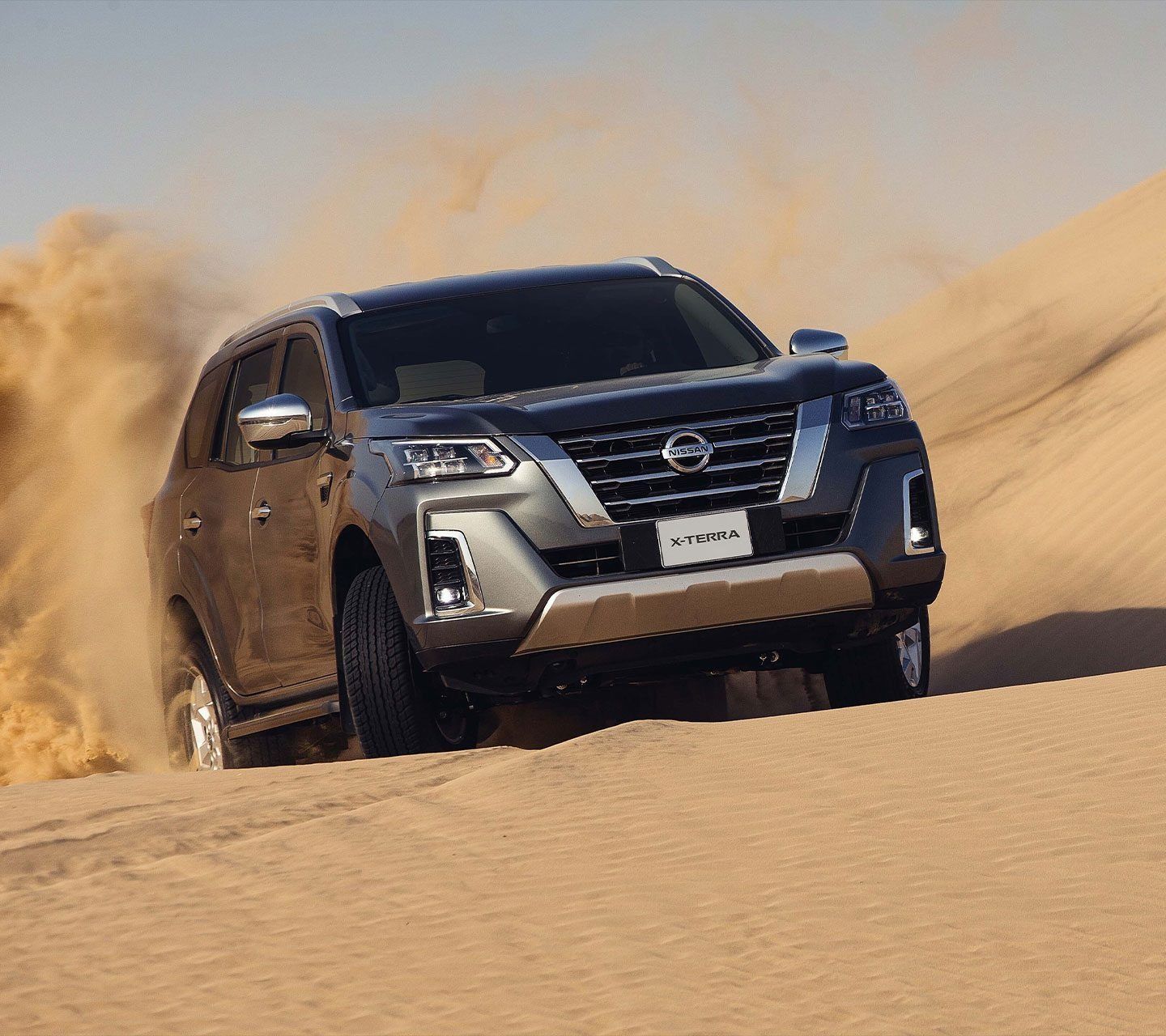 Nissan X-Terra SUV driving across desert dunes, demonstrating its rugged off-road capability and adventure-ready design.