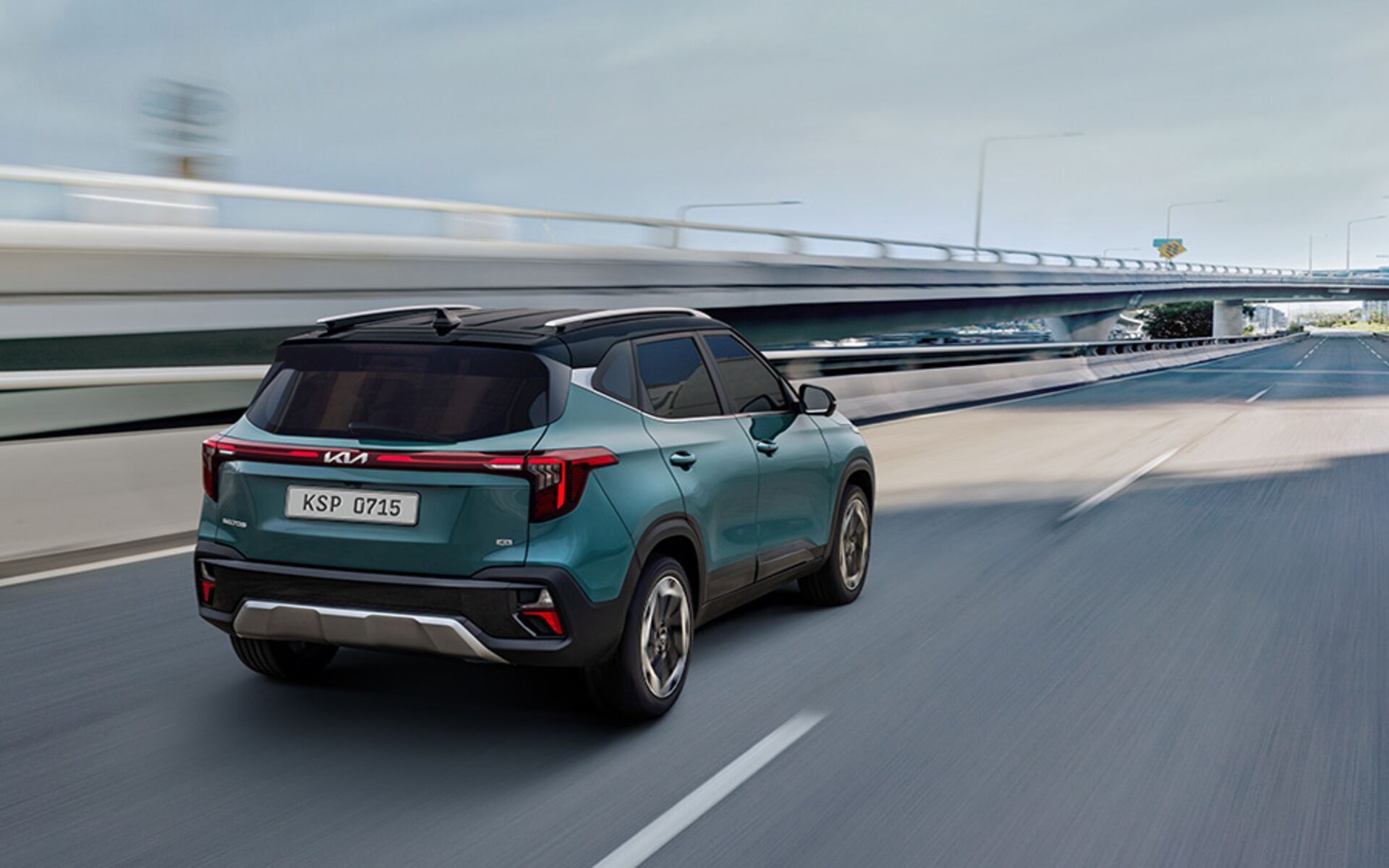 Kia Seltos driving on a highway with connected LED tail lamps and modern SUV design.