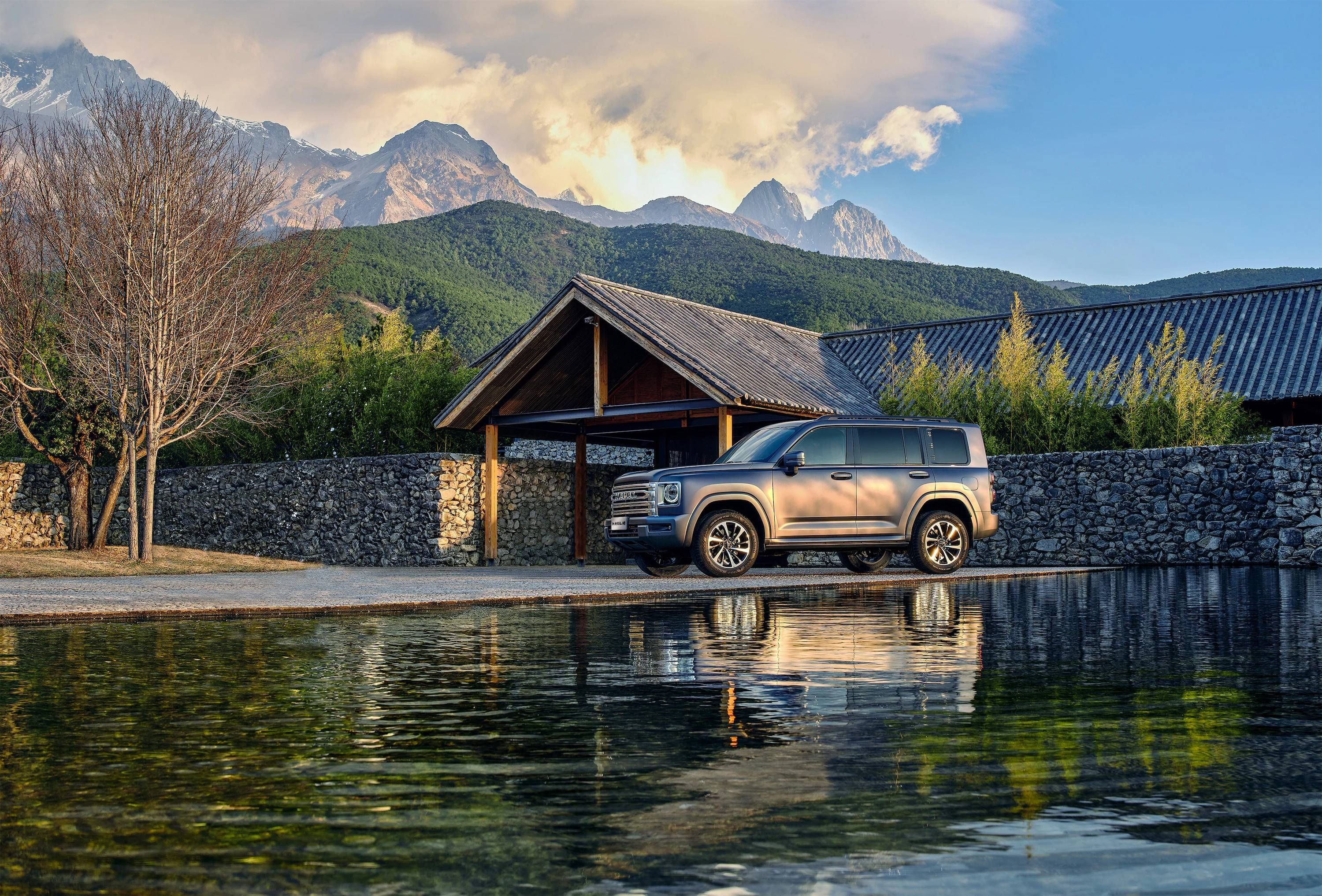 Haval H9 SUV by a lakeside with mountain views