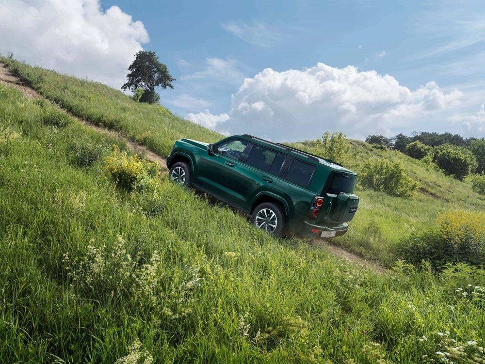Haval H9 climbing a grassy hill during an off-road drive