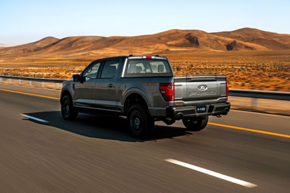 Ford F-150 driving through a desert highway with mountains in the background
