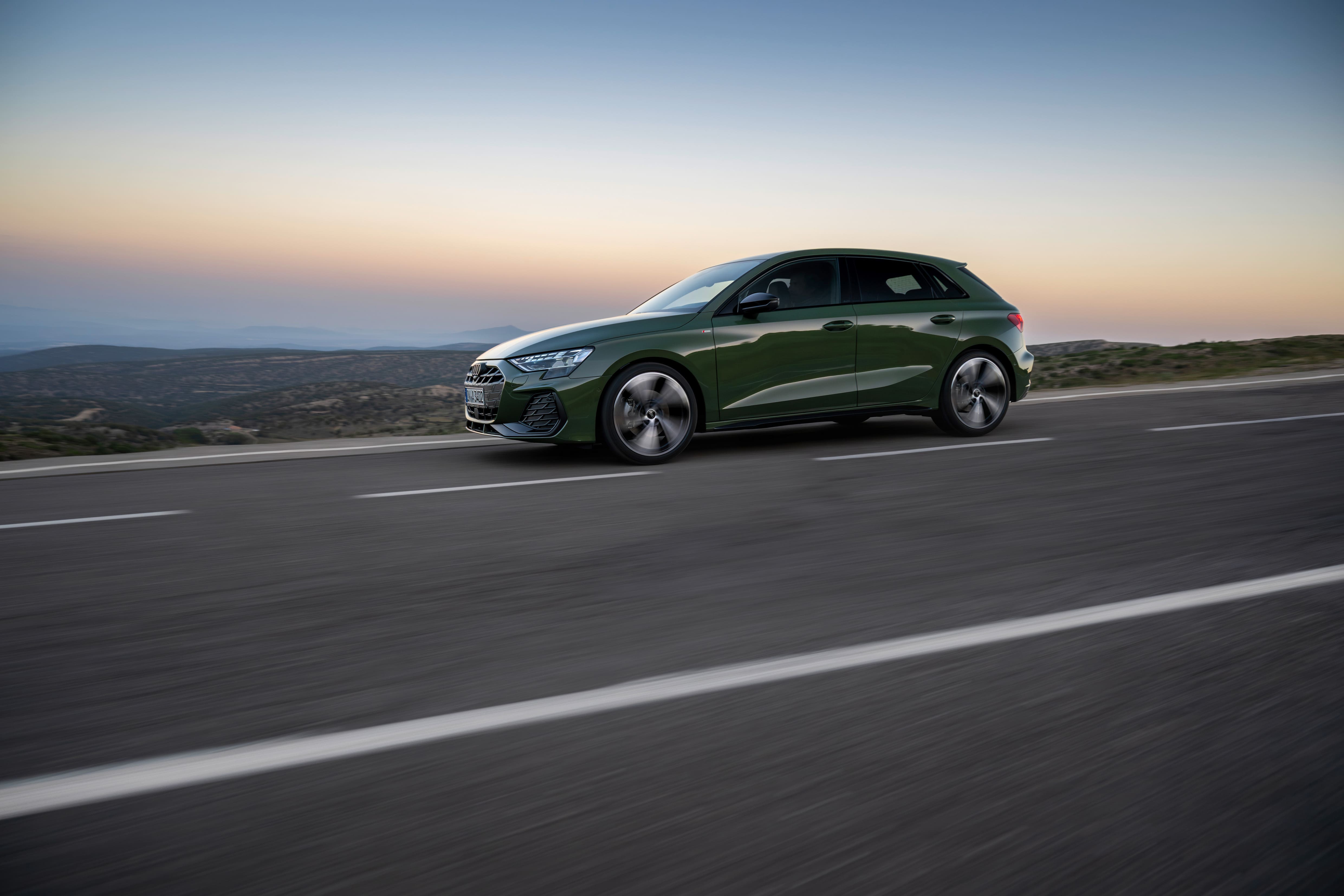 Side profile of the 2026 Audi A3 Sportback showcasing its refreshed design while driving at sunset.
