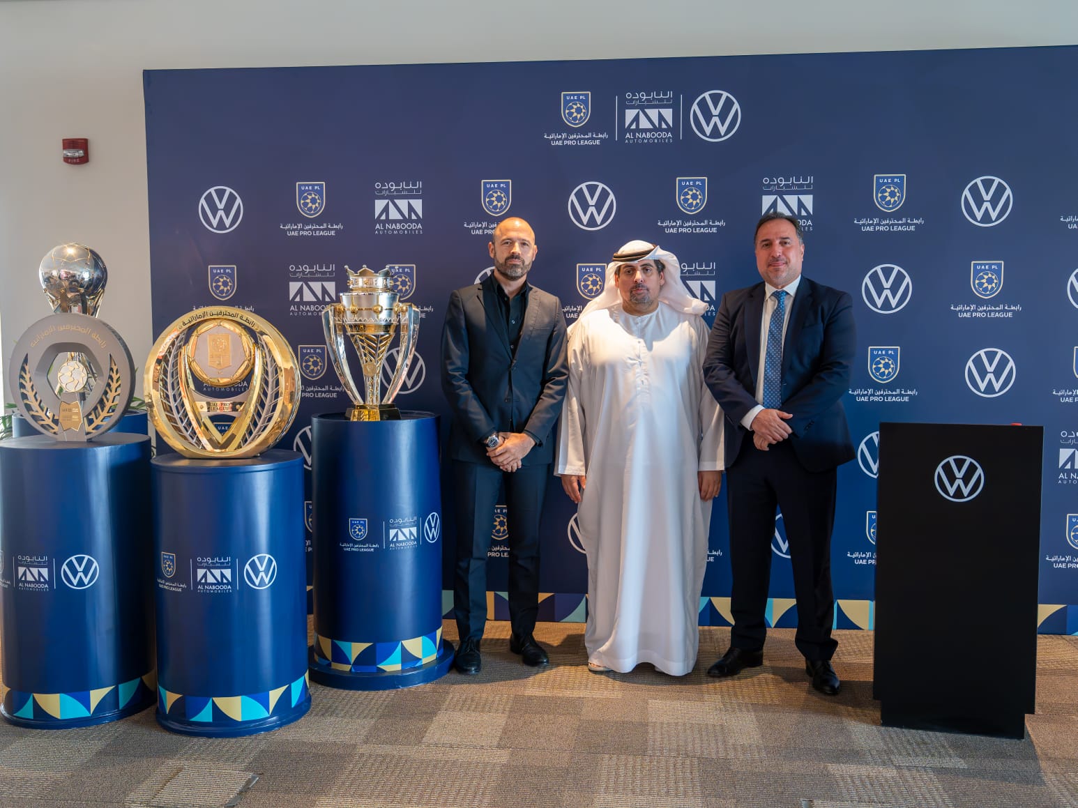Volkswagen Al Nabooda and UAE Pro League officials pose during the fleet partnership renewal ceremony alongside league trophies and Volkswagen branding.