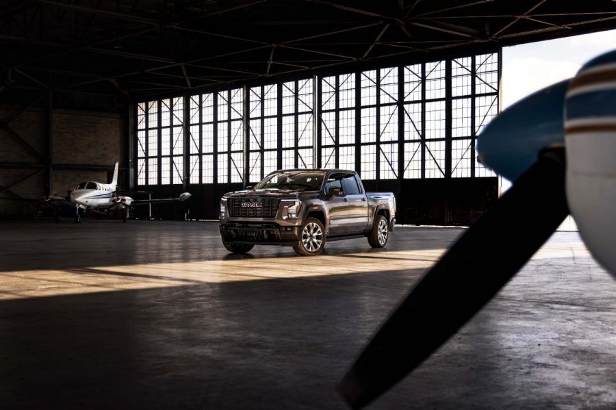 The 2027 GMC Sierra Denali Ultimate displayed inside an aircraft hangar, highlighting its premium exterior styling.