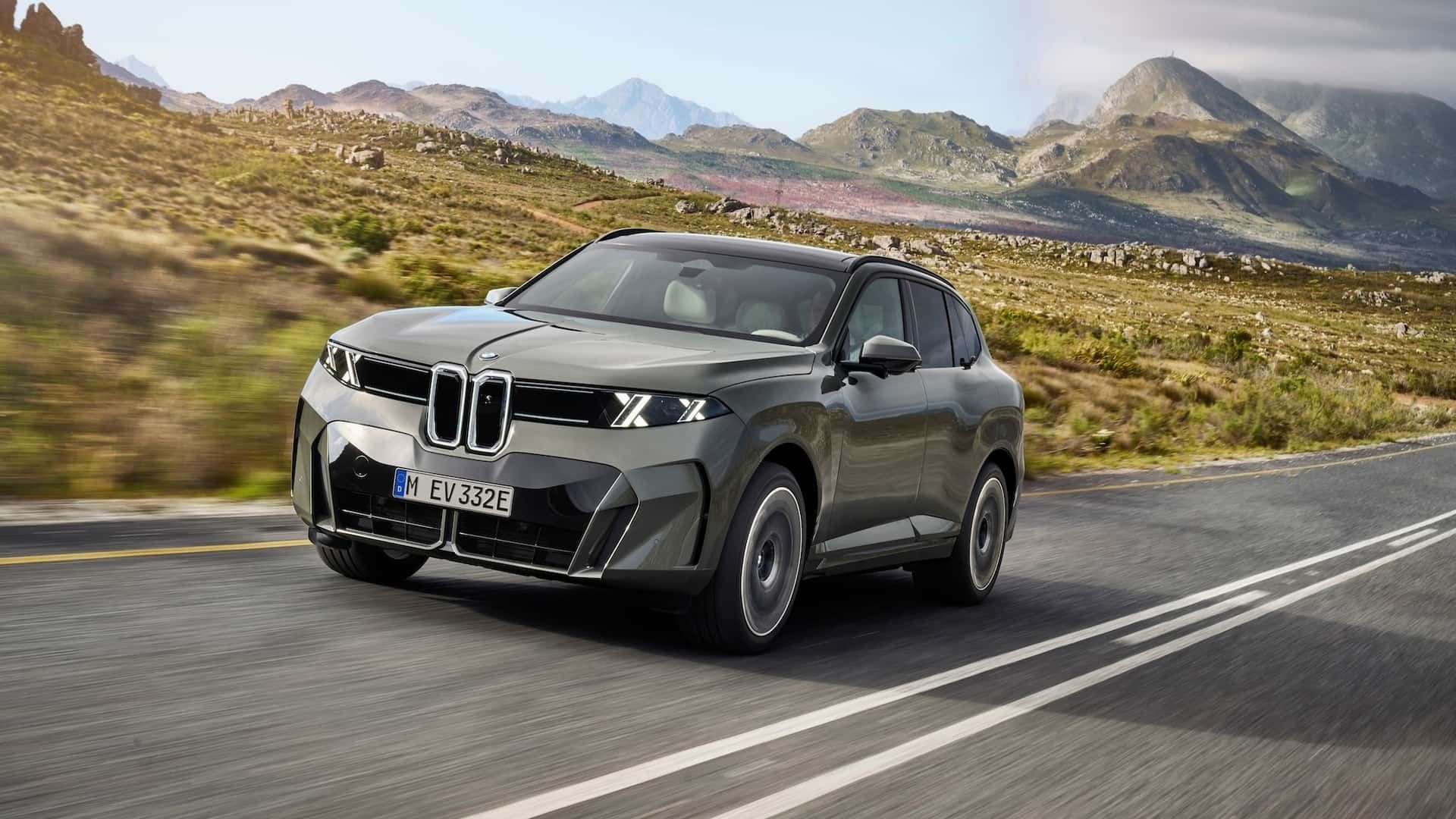 BMW X5 driving through mountain roads showcasing its SUV proportions and updated front styling.