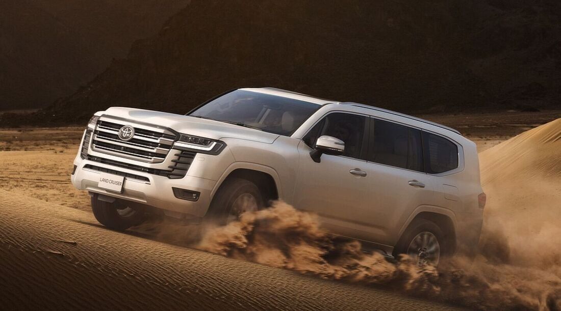 Toyota Land Cruiser driving through desert dunes