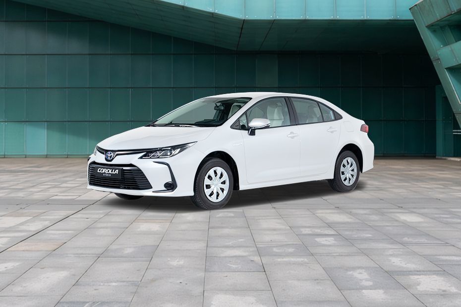 White Toyota Corolla Hybrid sedan parked, front three-quarter view.
