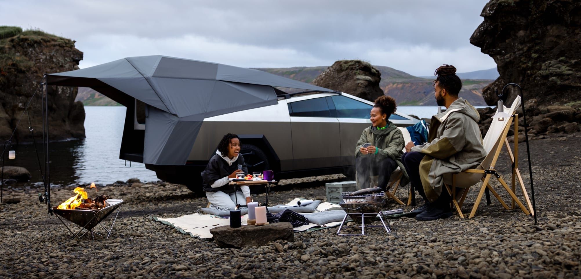 Tesla Cybertruck with Basecamp tent setup at a scenic campsite, showcasing outdoor adventure capabilities.
