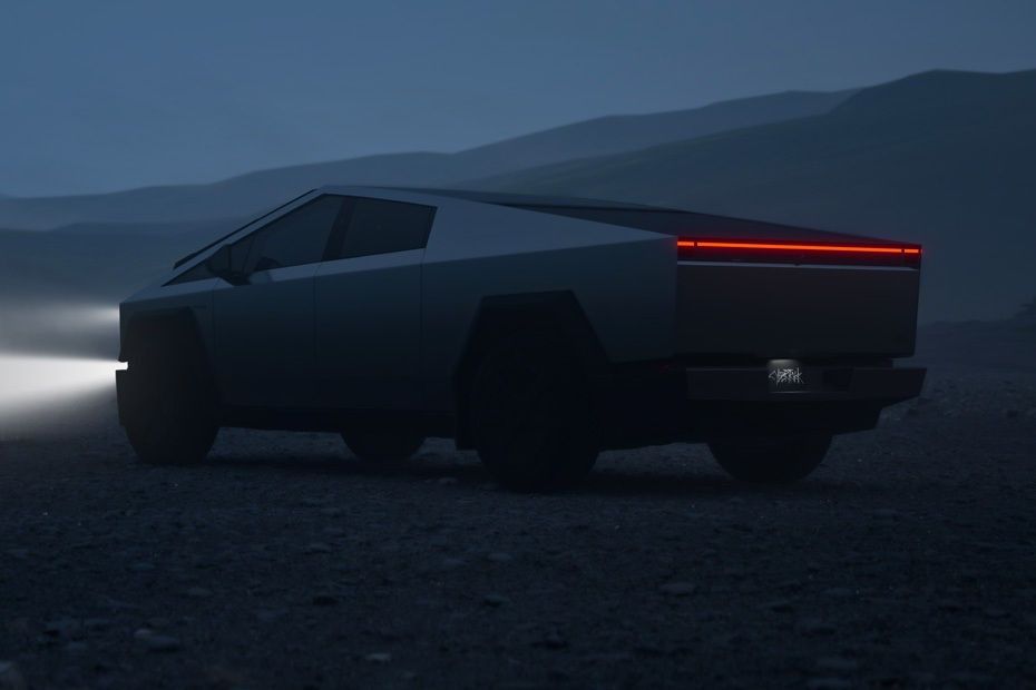 Tesla Cybertruck rear view with full-width LED light bar on an off-road trail