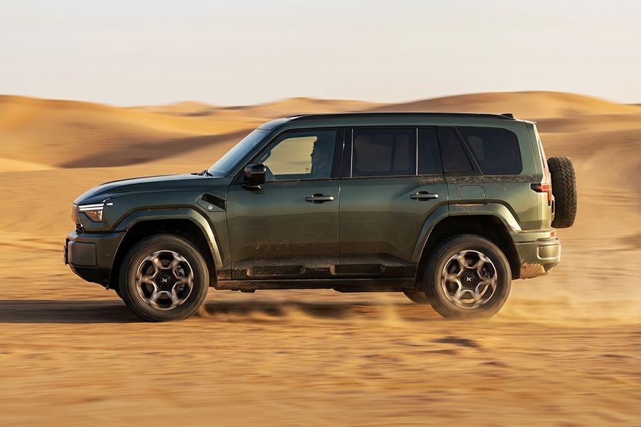 MHERO 2 side profile driving across desert dunes with rugged off-road styling