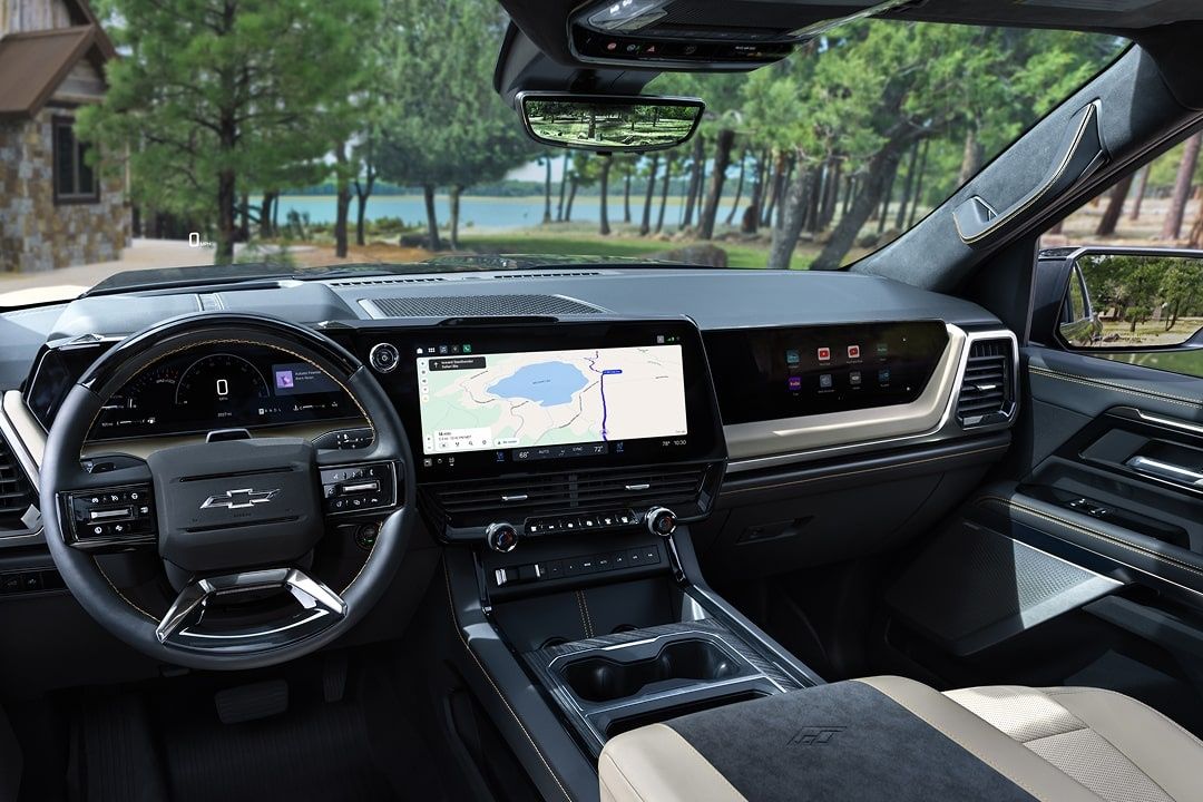 2027 Chevrolet Silverado 1500 towing a boat on a scenic highway