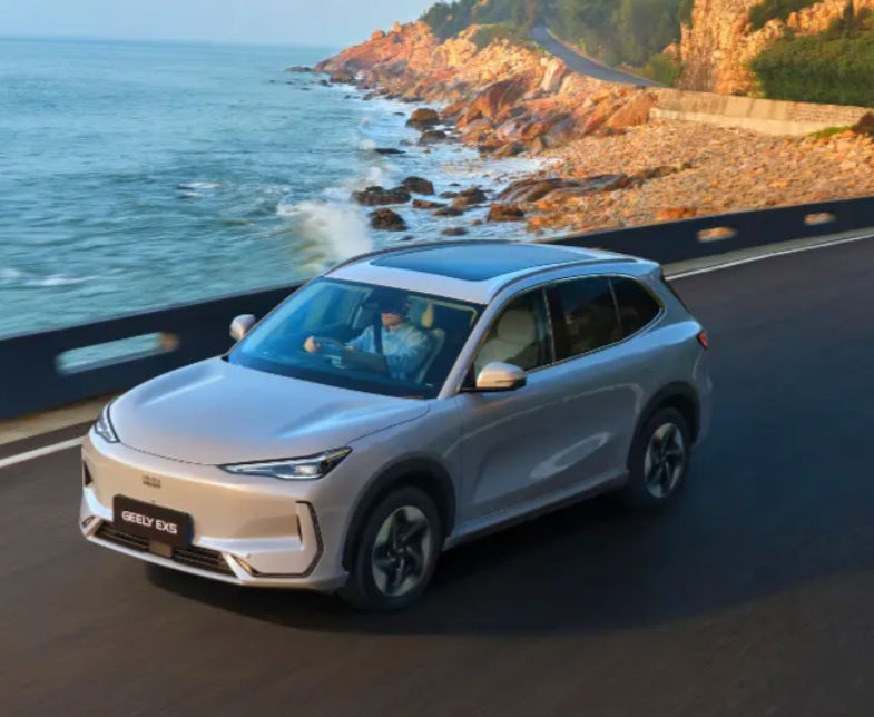 Geely EX5 electric SUV driving along a scenic coastal road with ocean views.