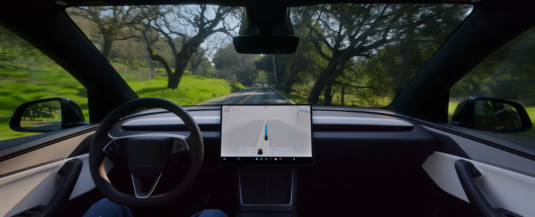 Tesla Model Y minimalist interior with central touchscreen and panoramic windshield