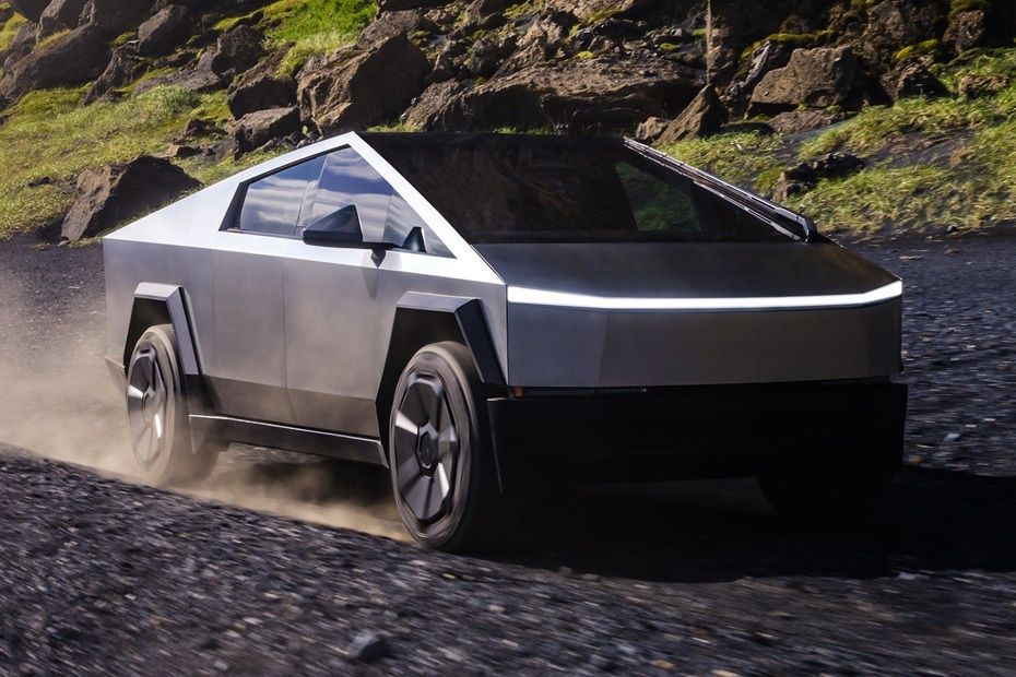 Tesla Cybertruck driving on a rocky mountain road.
