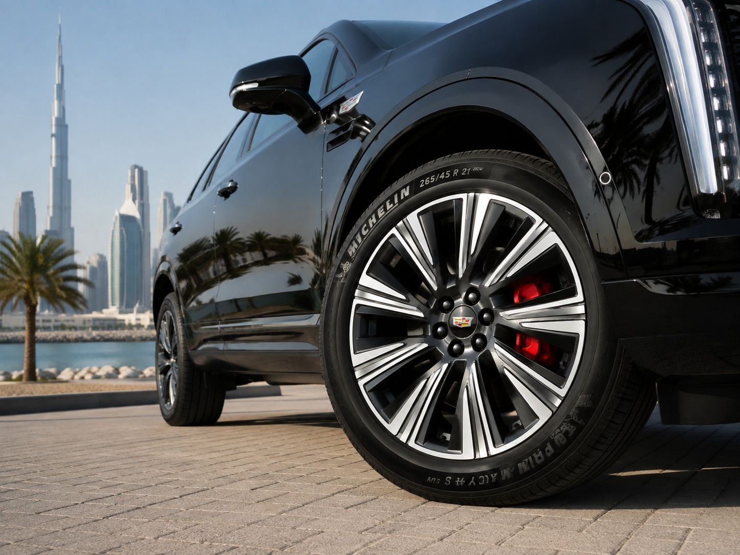 Black Cadillac XT5 PHEV with alloy wheels on a UAE waterfront road.