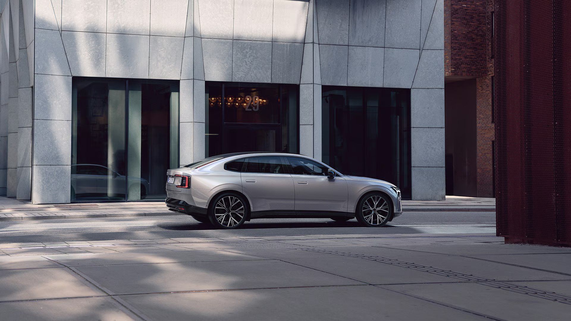 Volvo ES90 parked on a city street outside a modern building.